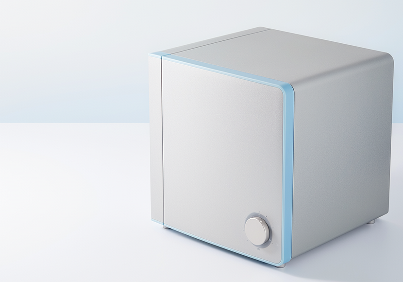青いアクセントラインと丸いつまみが付いた、キューブ型の灰色の家電製品